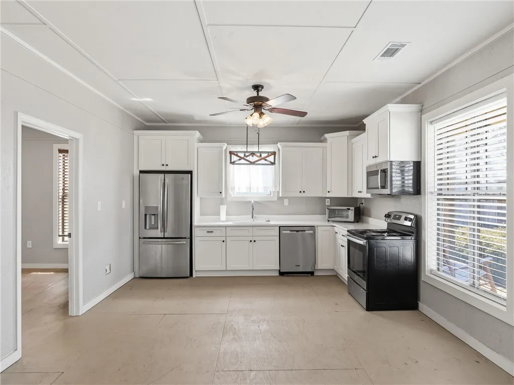 A well-lit kitchen with sleek stainless steel appliances awaits your culinary touch.