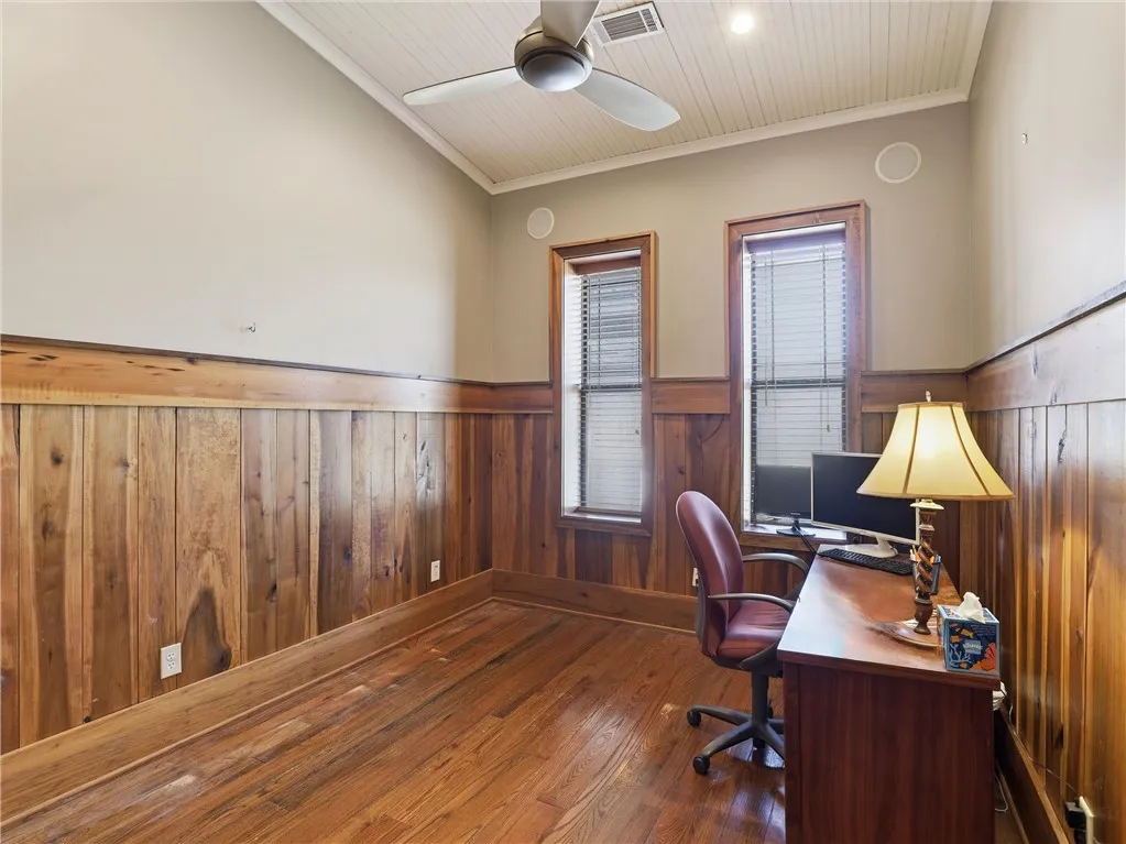 Rich hardwood floors complement detailed wood paneling, creating a productive and handsome workspace.
