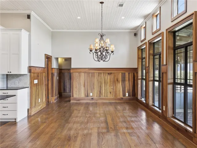 Warm wood accents complement the generous natural illumination and charming chandelier.