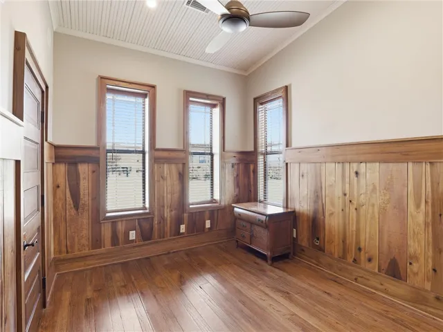Natural wood paneling and gleaming hardwood floors define this inviting interior space.