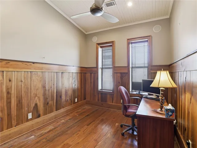 Rich hardwood floors complement detailed wood paneling, creating a productive and handsome workspace.