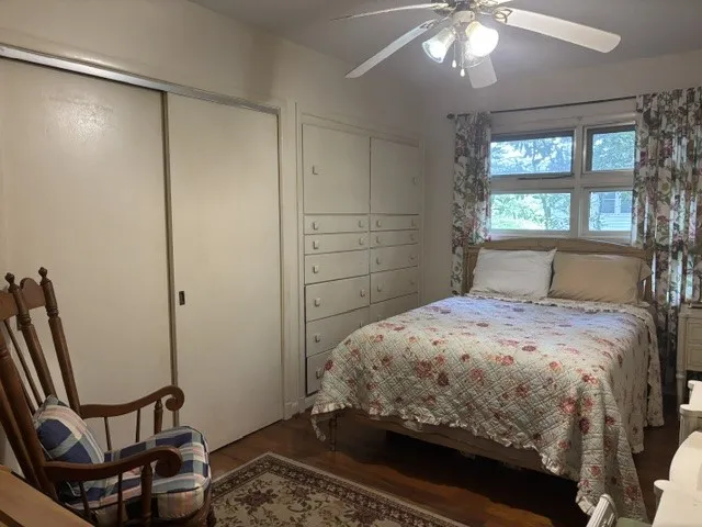 A comforting bedroom space features ample storage and a cheerful window view.