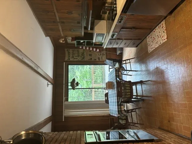 A quaint eat-in kitchen with wood accents overlooks verdant views.