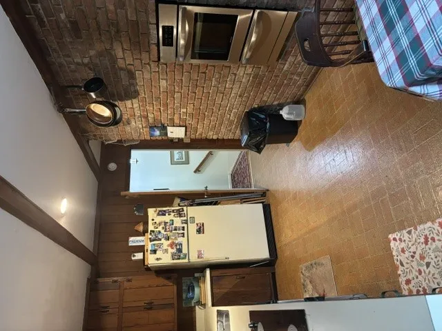 A well-lit kitchen with classic brick accents and durable tile flooring, perfect for daily living.