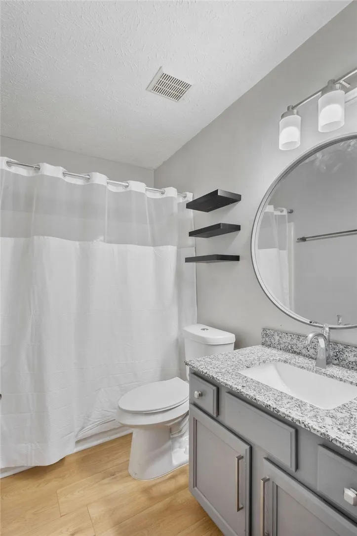 A sleek vanity with granite counters anchors this modern bathroom.