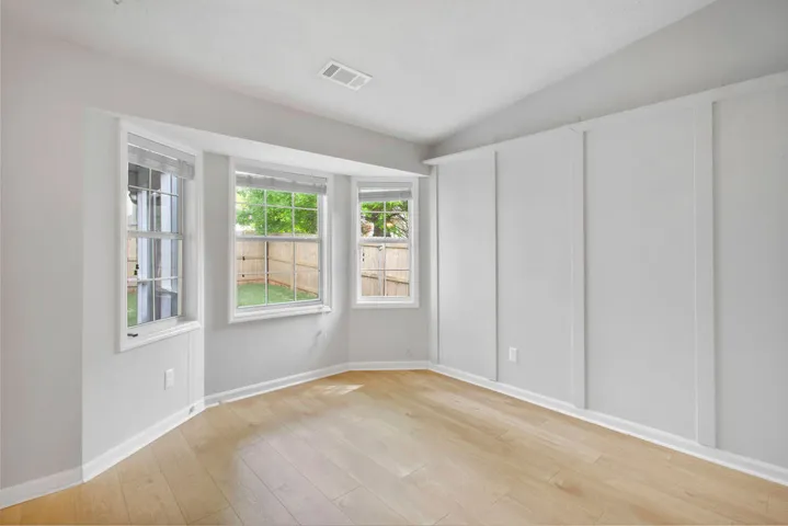 Sun-filled room boasts bay windows and board and batten wall details.