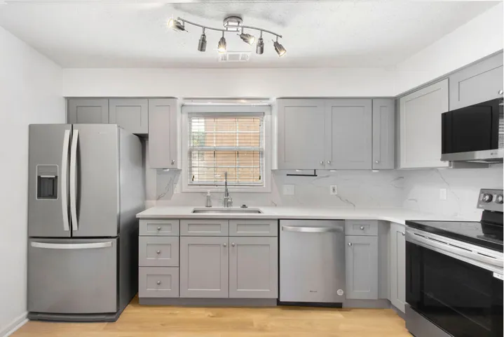 A well-appointed culinary space featuring stainless steel appliances and light wood flooring.