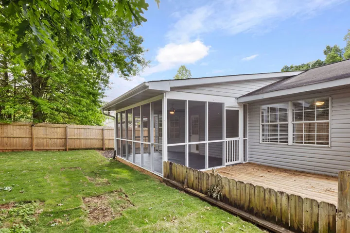 A private outdoor space features a spacious screened porch and an adjoining deck for leisure.