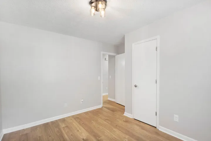 Laminate flooring extends through this room and into the adjoining hallway, creating a unified flow.