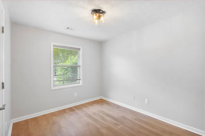 Laminate flooring and a window with blinds define this tranquil room.