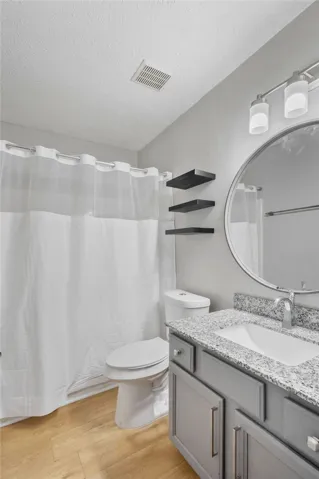 A sleek vanity with granite counters anchors this modern bathroom.