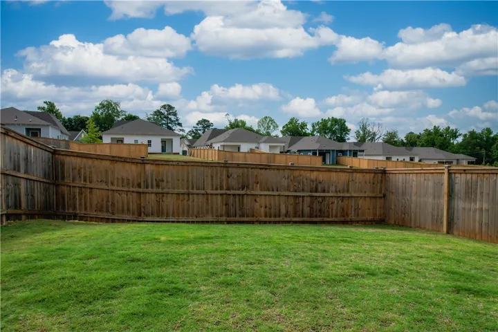 A verdant backyard with a privacy fence bordering a serene residential neighborhood.