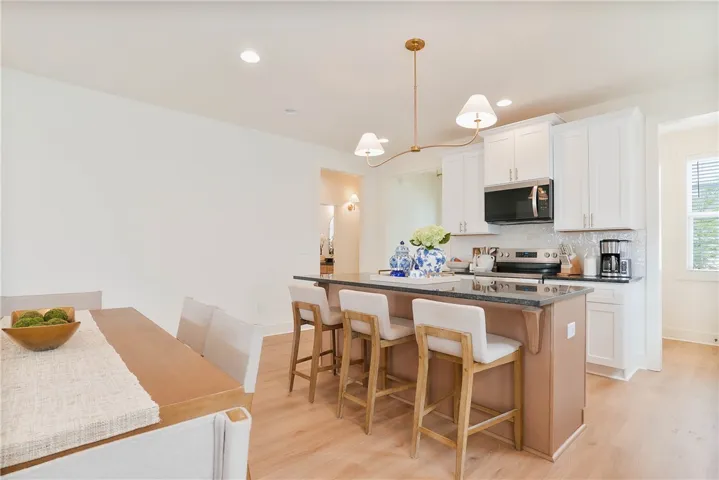 Culinary adventures await in this naturally illuminated kitchen with a granite island, perfect for entertaining.