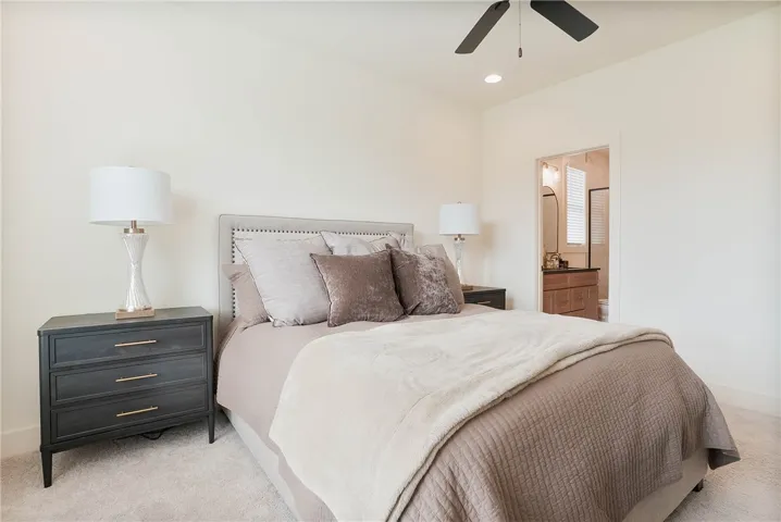Well-lit sleeping quarters with plush carpeting offers direct access to an adjacent bath.