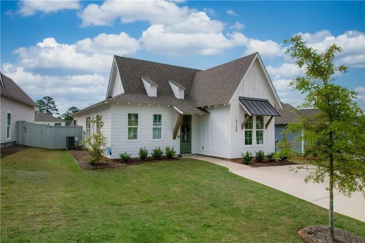 A classic white home with striking dark roof and charming dormer windows.