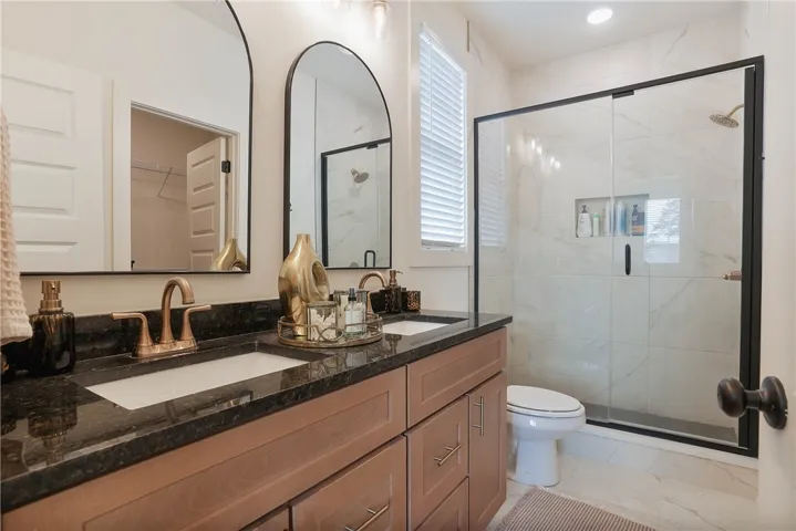 Dual vanities with dark countertops and modern fixtures create a refined bathing experience.