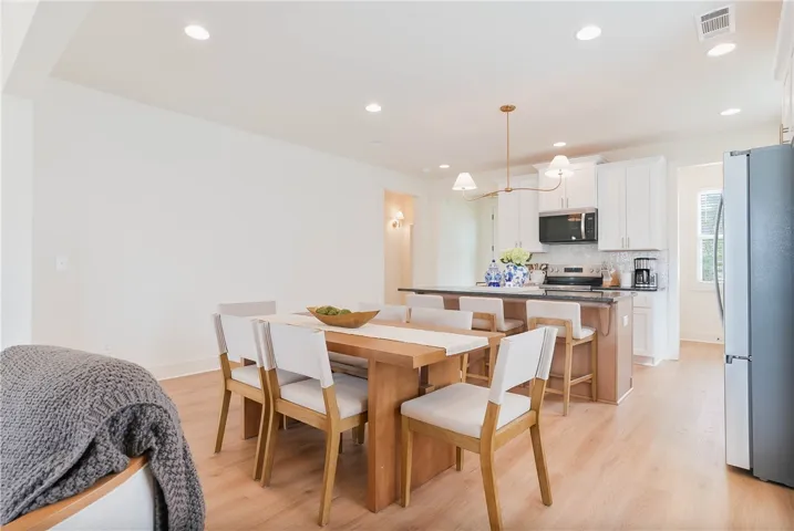 An inviting open-concept space features a contemporary kitchen island and a casual dining area.