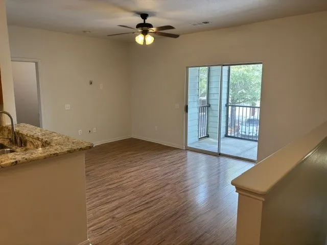 A living space offers a smooth transition to an outdoor balcony through wide sliding glass doors.