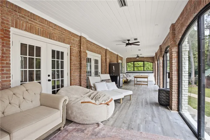 A spacious sunroom with brick walls and large windows offers an ideal indoor-outdoor living experience.