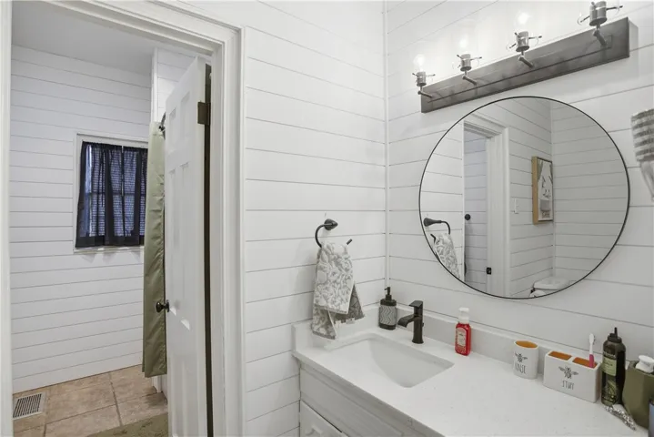 Bright white shiplap walls and a modern vanity create a clean, contemporary bathroom aesthetic.