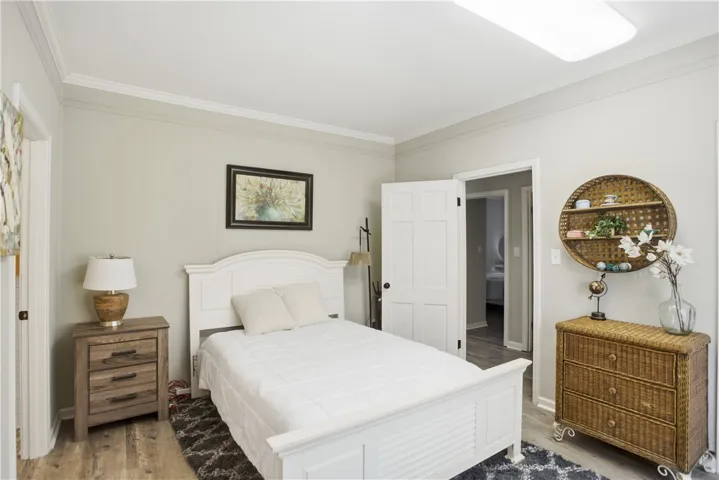Hardwood-style flooring and crown molding enrich this inviting bedroom.