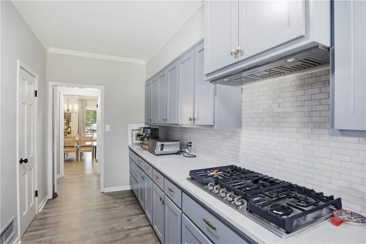 Culinary delights await in this modern galley kitchen featuring sleek cabinetry and a gas cooktop.