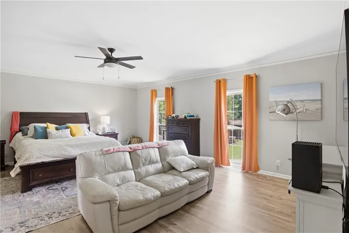 Hardwood floors and bright windows illuminate this spacious and comfortable primary bedroom.