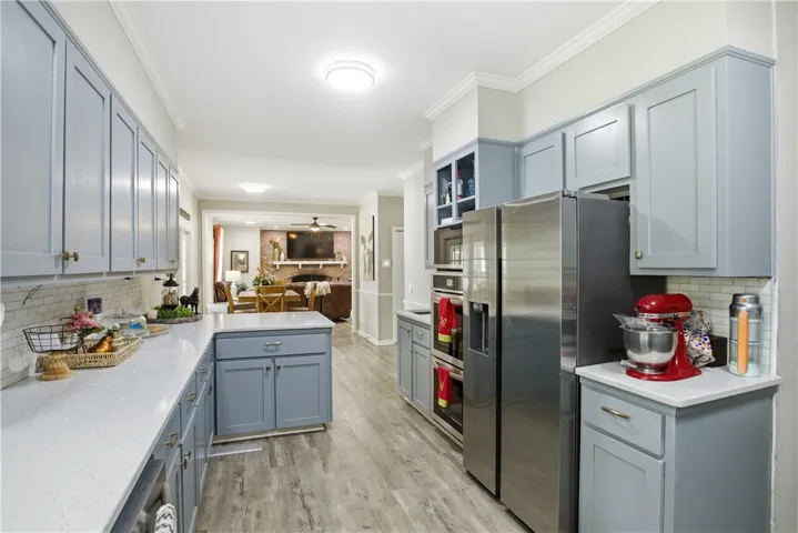 An inviting open-concept kitchen features sleek stainless steel appliances and durable hardwood flooring.