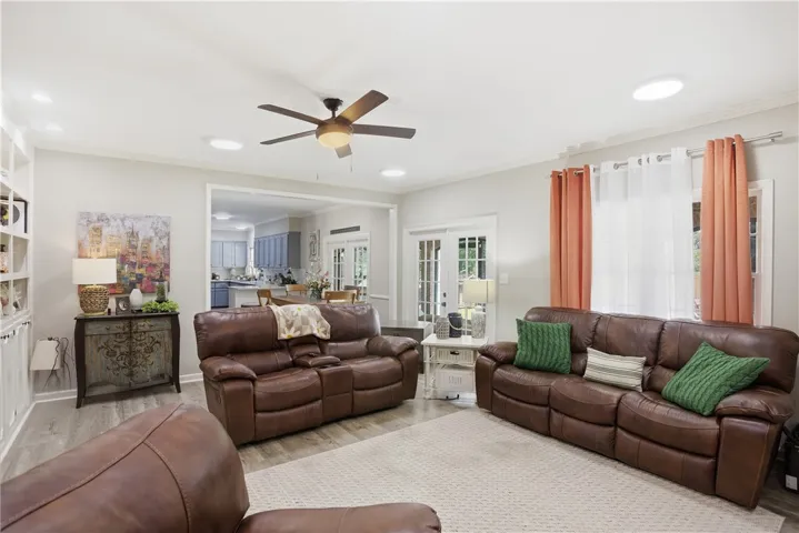 Discover a naturally illuminated living space featuring modern flooring and an open flow to the kitchen beyond.