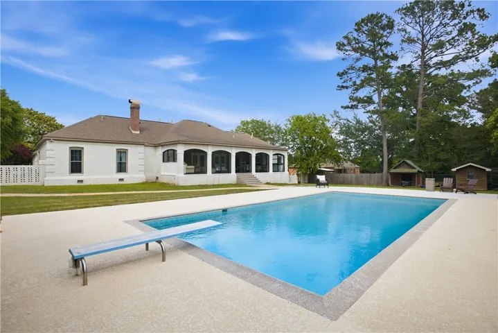 An inviting backyard oasis offers a pristine inground pool, perfect for leisure under the open sky.