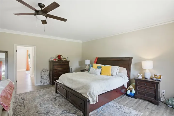 Ceiling fan and subtle crown molding define this comfortable, well-appointed bedroom space.