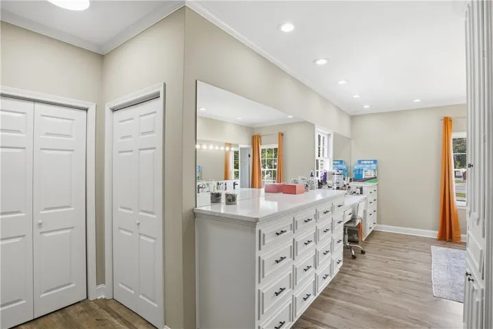 Well-lit room featuring ample built-in storage with a large mirror and windows.