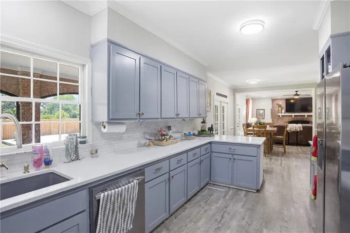 A well-lit kitchen with sleek cabinetry seamlessly connects to a cozy living area, creating an inviting open floorplan.