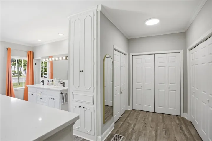 White custom cabinetry and dual vanity enhance this well-appointed primary bathroom.