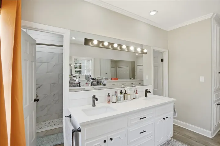 Dual vanities and a tiled shower offer refined comfort in this well-appointed bath.