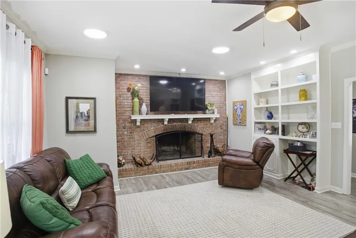 A classic brick fireplace anchors this inviting living space, complemented by built-in shelving.