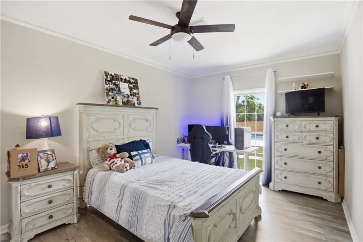 Well-lit room with wood flooring provides a comfortable space for rest or study, featuring a desk area and a pool view.