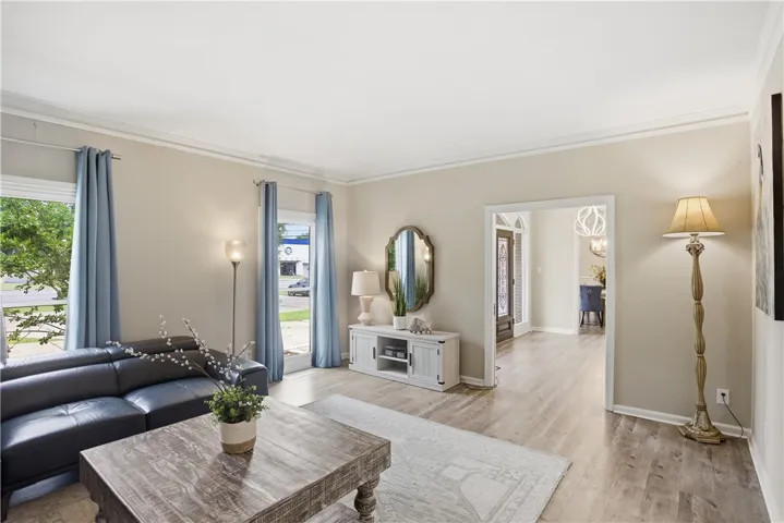 Elegant crown molding graces the ceilings of this inviting living area with light-toned flooring.