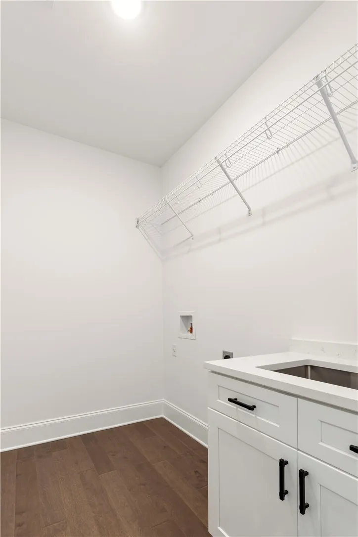 A well-appointed laundry room features ample storage and a convenient utility sink.