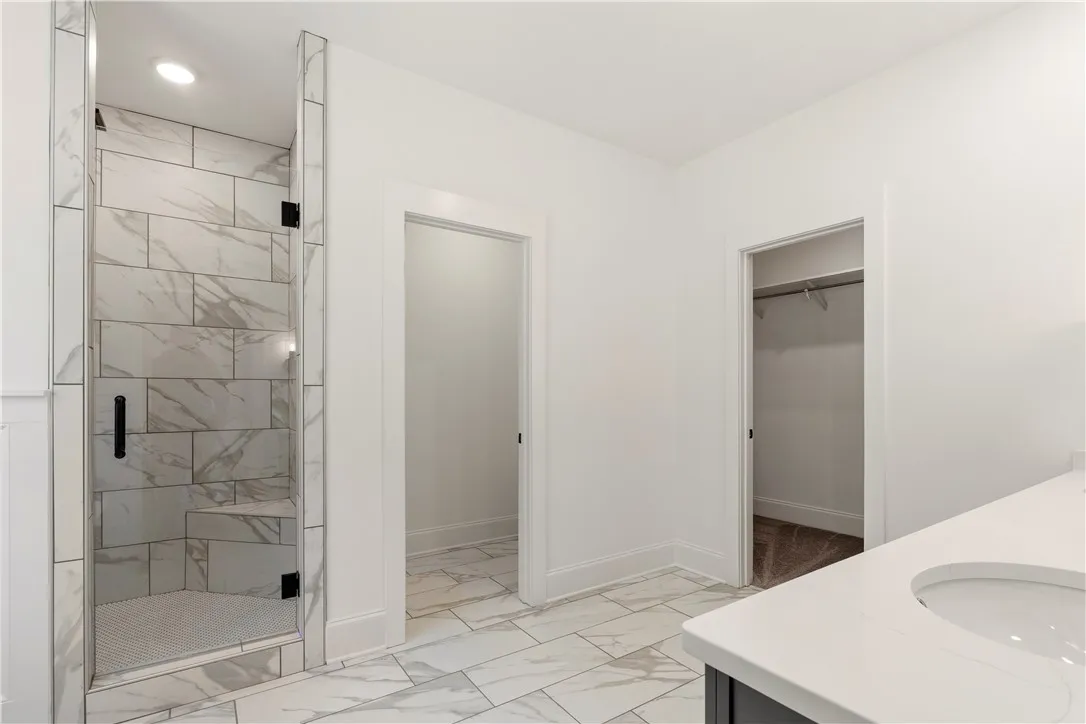 A well-appointed primary bathroom featuring a spacious walk-in shower and ample vanity space.