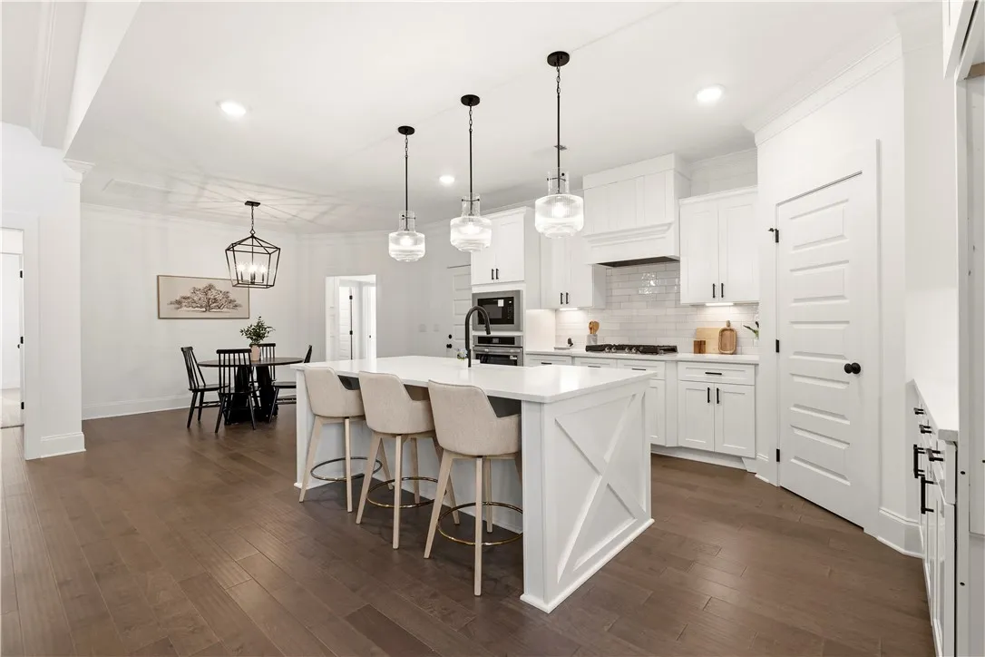Bright, open-concept kitchen and dining area feature rich wood flooring and recessed lighting.