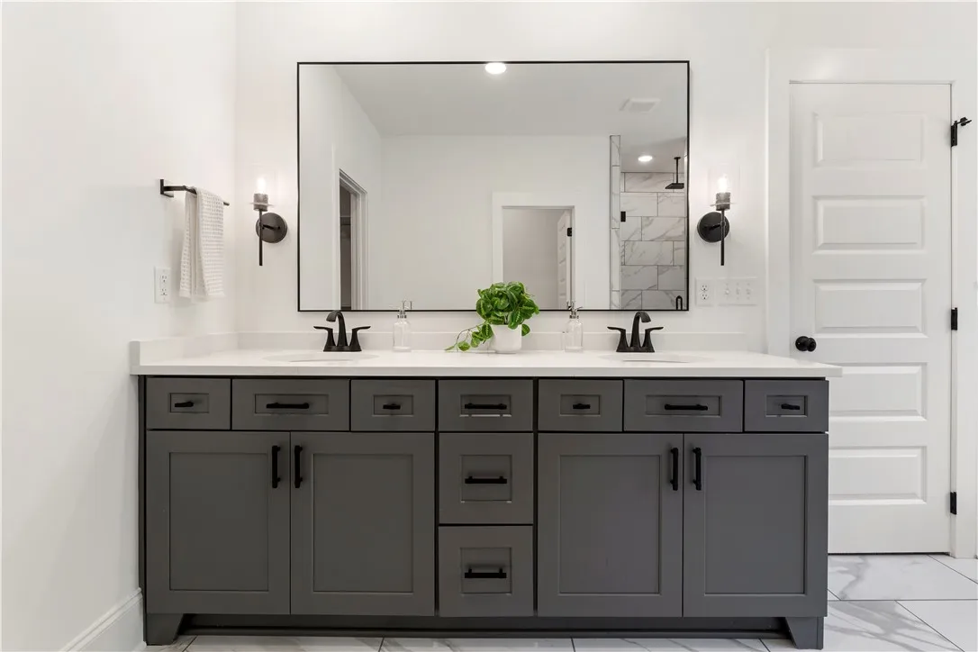 A generously sized dual vanity with ample storage anchors this bright, contemporary primary bathroom.