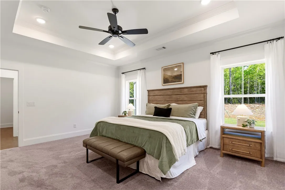 A well-lit bedroom with a tranquil outdoor view, featuring a handsome wood-paneled headboard.