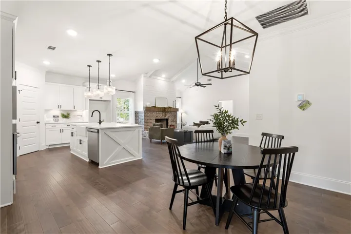 An open concept floorplan seamlessly connects the well-lit kitchen, dining area, and cozy living space.