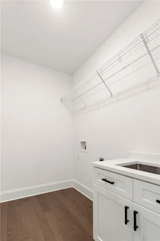 A well-appointed laundry room features ample storage and a convenient utility sink.