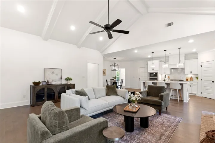 Vaulted ceilings and rich wood flooring define this open-concept living space with an integrated kitchen.