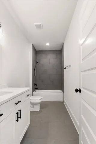 A well-appointed bath features a sleek vanity, modern fixtures, and tile flooring.