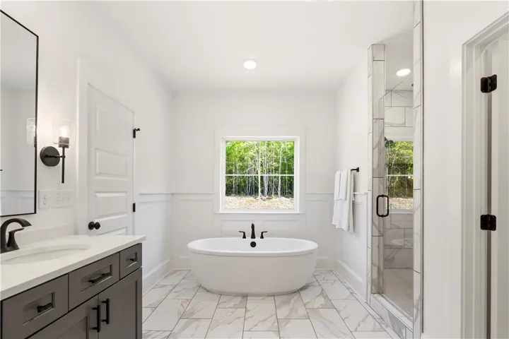 Luxurious bathroom with a freestanding tub and walk-in shower, showcasing elegant tile work.