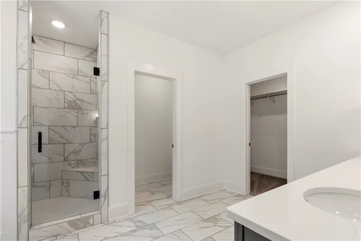 A well-appointed primary bathroom featuring a spacious walk-in shower and ample vanity space.