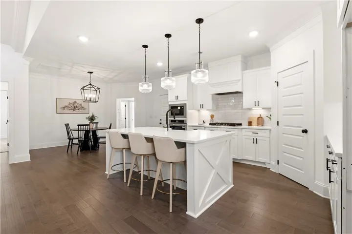Bright, open-concept kitchen and dining area feature rich wood flooring and recessed lighting.